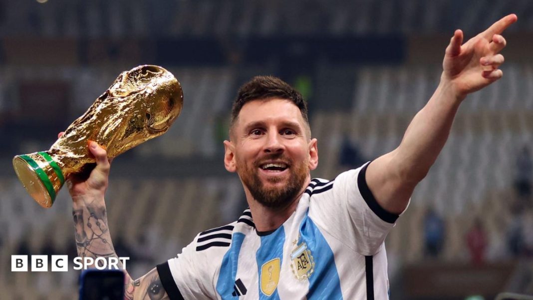 Lionel Messi holding the World Cup trophy in an Argentina shirt. Getty Images via BBC Sport.