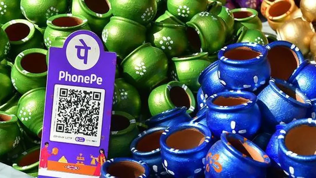 A PhonePe QR stand among painted pots at a market stall. Murali Kumar K via The Hindu Business Line.