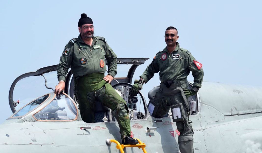 Group Captain Abhinandan Varthaman (right) standing on a fighter jet with an IAF colleague. File photo, via The Tribune